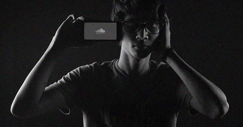 Image of an individual with a phone in hand displaying the SoundCloud logo