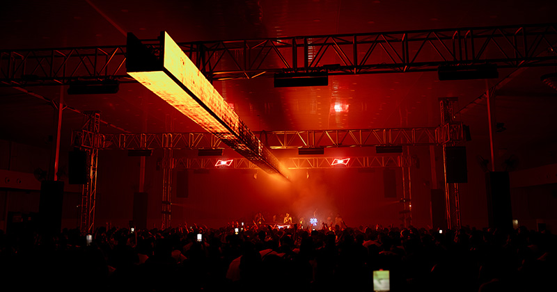 Crowd dancing under vibrant lights at a DGTL India electronic music festival.